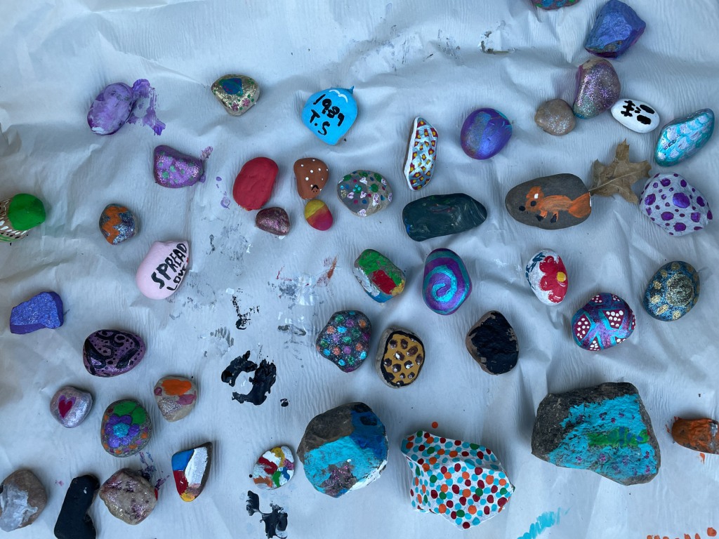 Painted rocks spread out on a sheet.