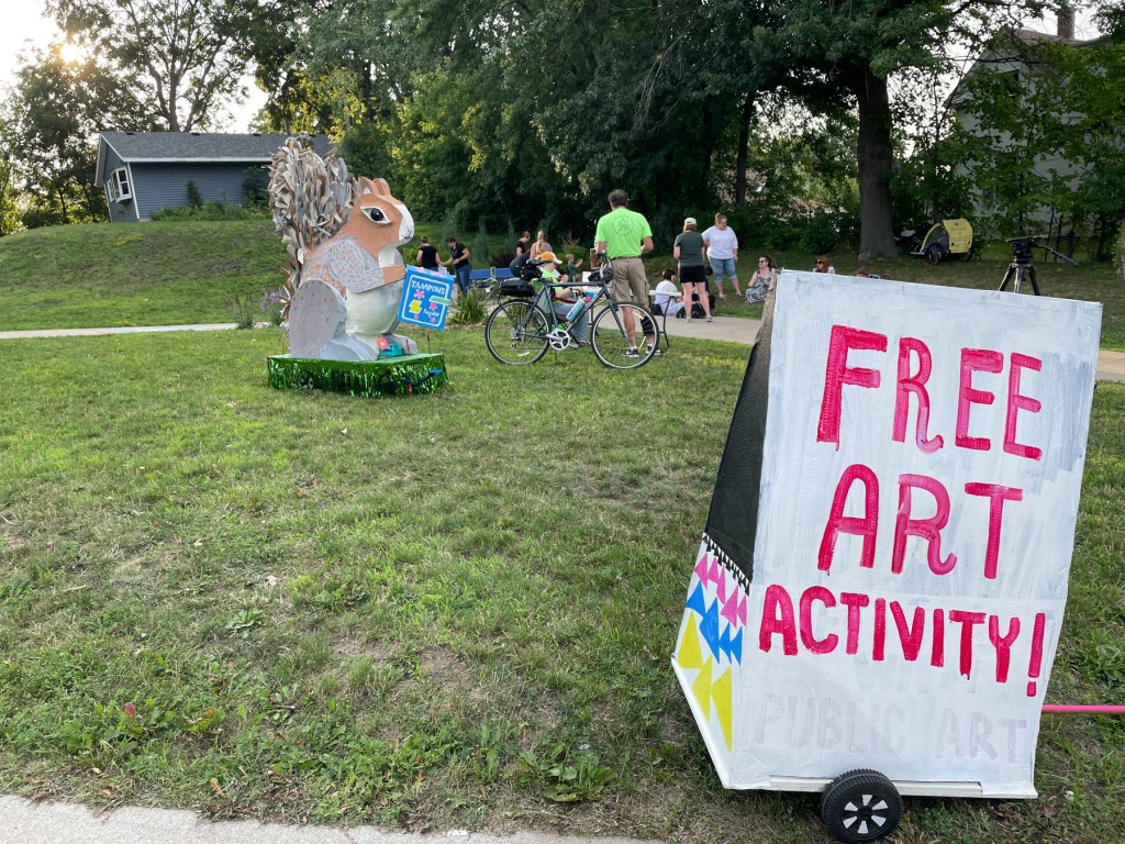 "Free Art Activity!" sign with giant squirrel in background.
