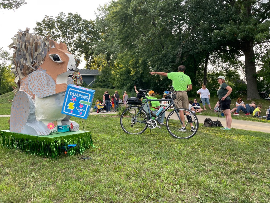 Giant squirrel sculpture with tampon box with people in the background.